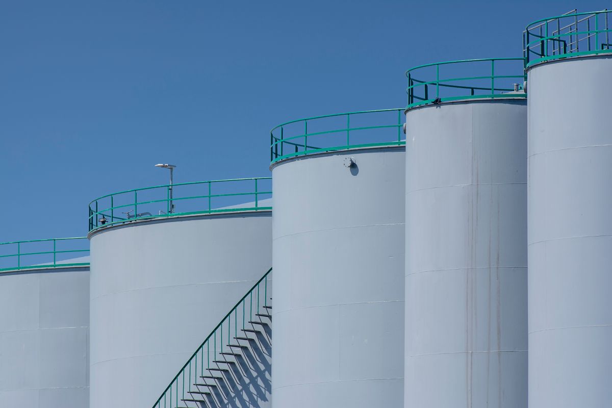 Reihe großer industrieller Lagertanks mit Geländern und Treppe